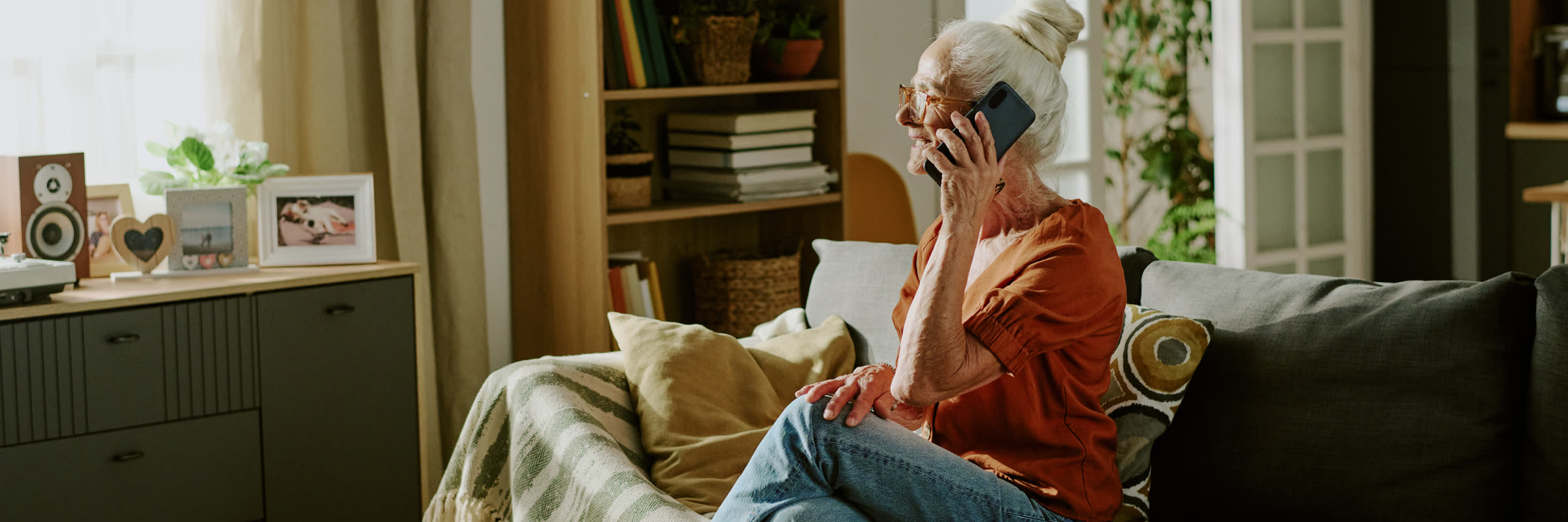 A woman chatting on the phone in a cozy living room